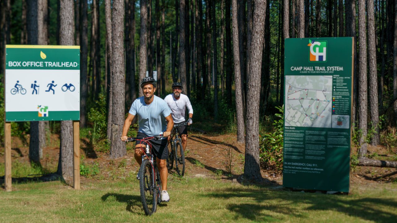 Two men biking on Camp Hall trails